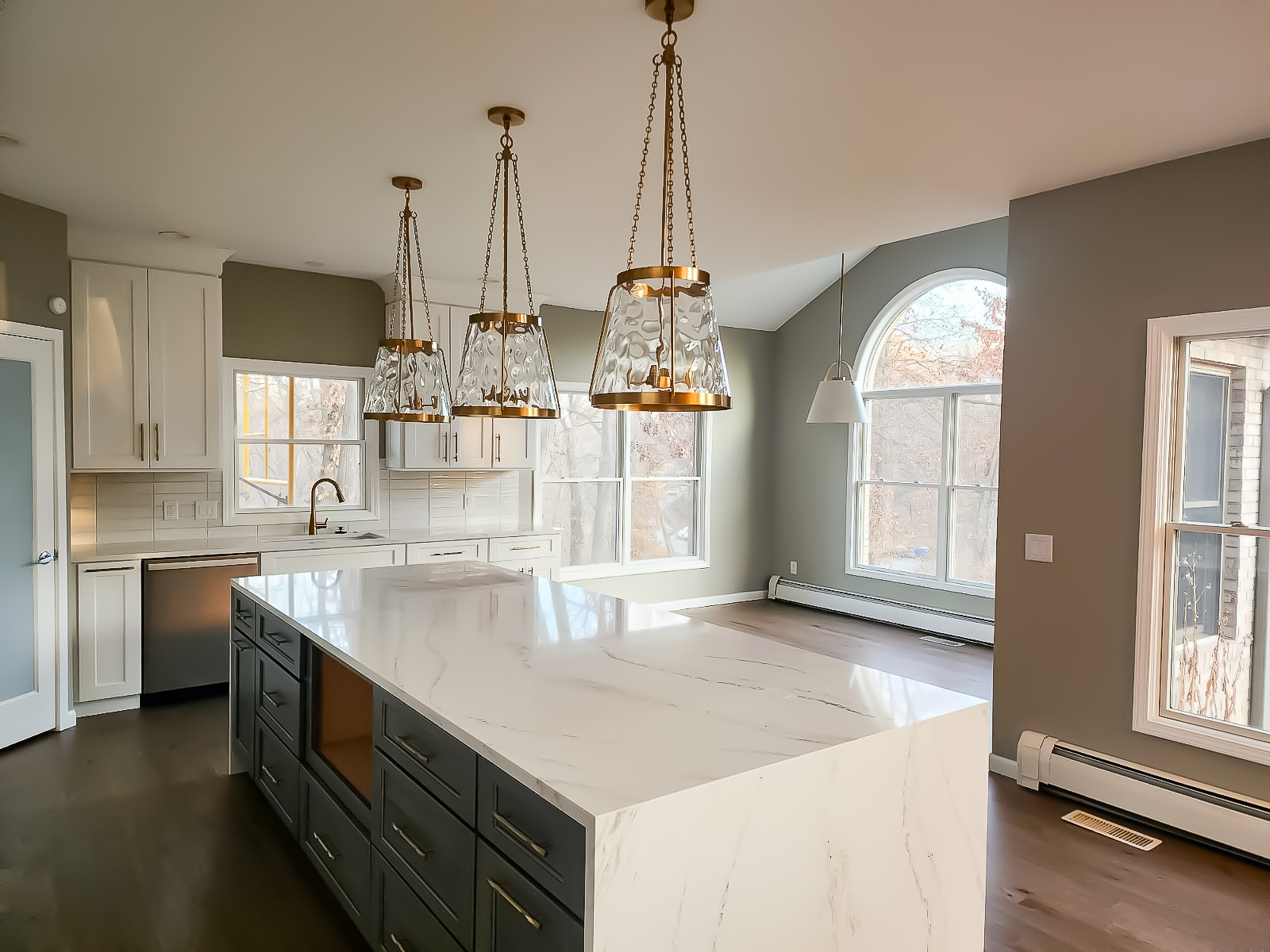 Image of a modern, classic kitchen with a marble island and copper light fixtures